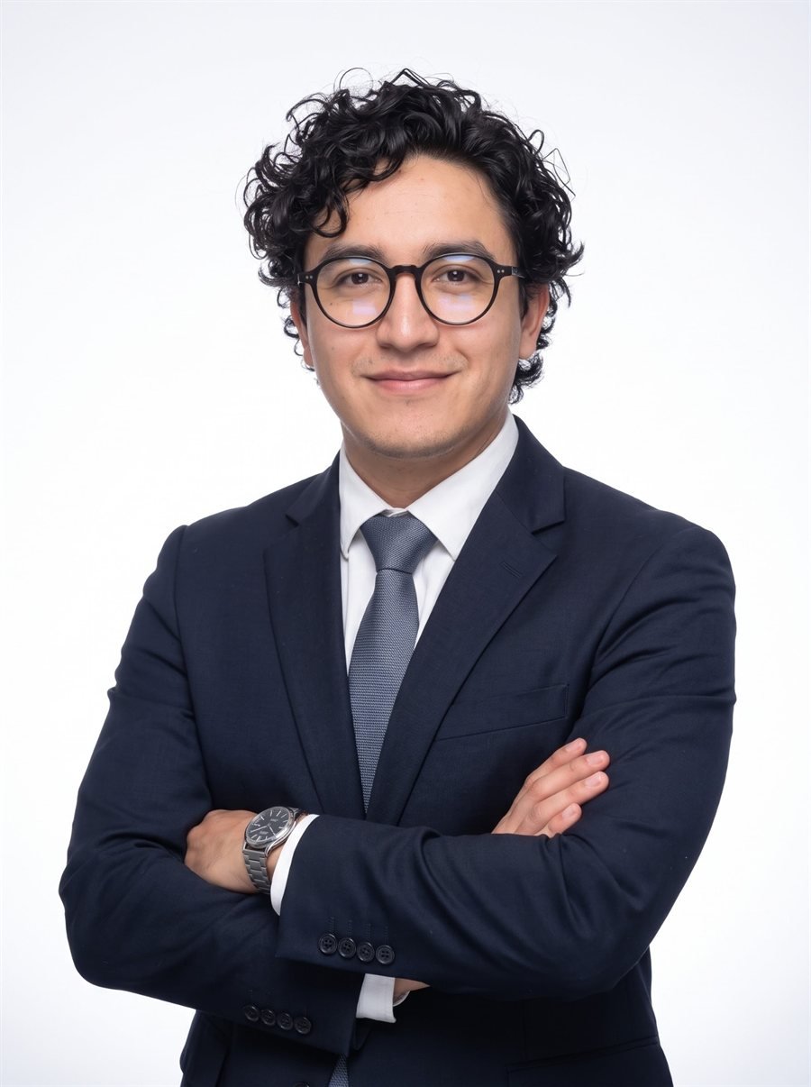 Retrato del Dr. Francisco Macías con traje azul marino y lentes, de brazos cruzados